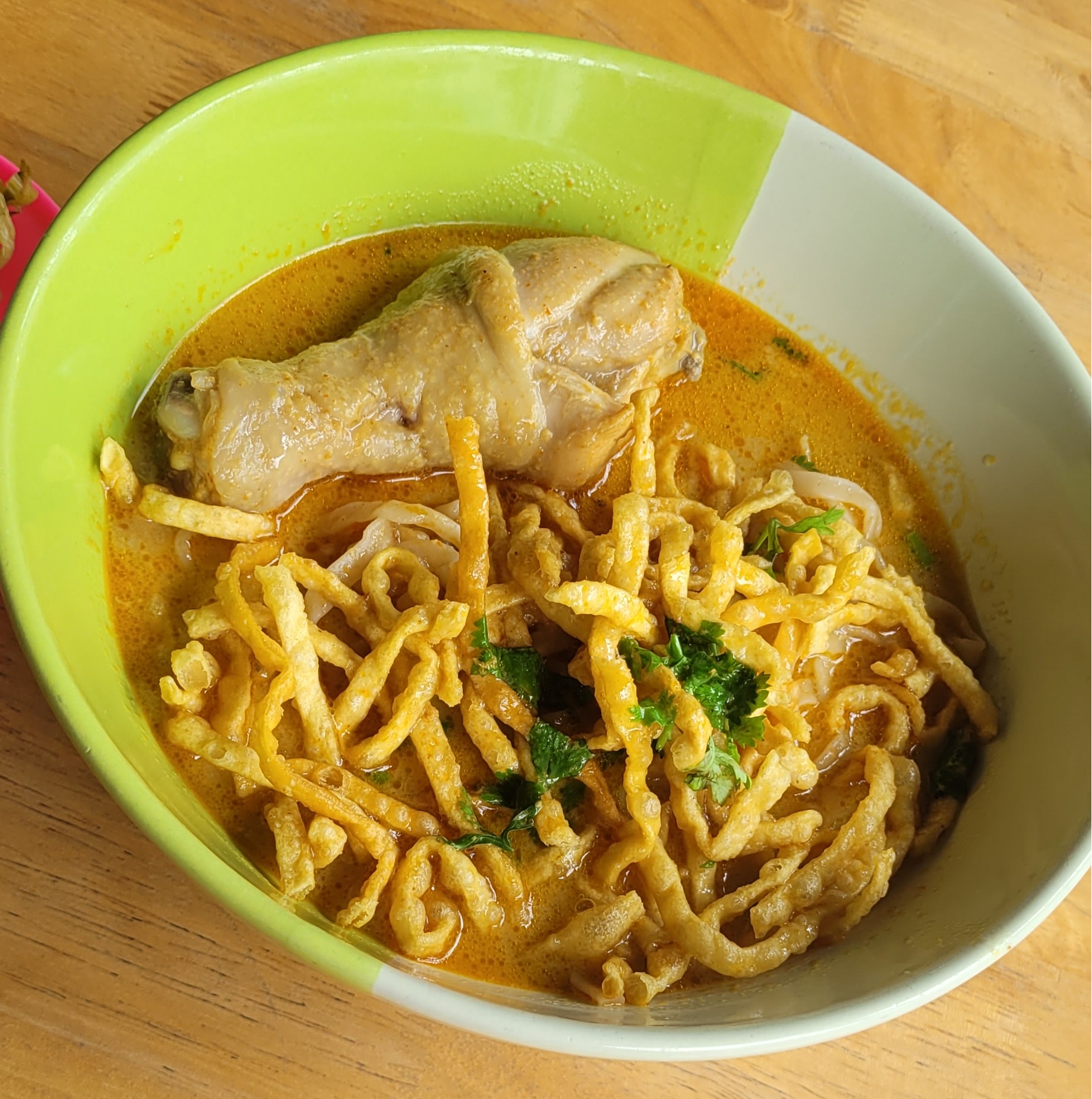 카오소이(KhaoSoi). 코코넛커리 국물에 부드러운 달걀면과 튀긴 면이 어우러져 식감도 재밌다. 고명으로 절인 겨자잎, 라임, 양파, 고추기름이 곁들여 풍미를 더한다.