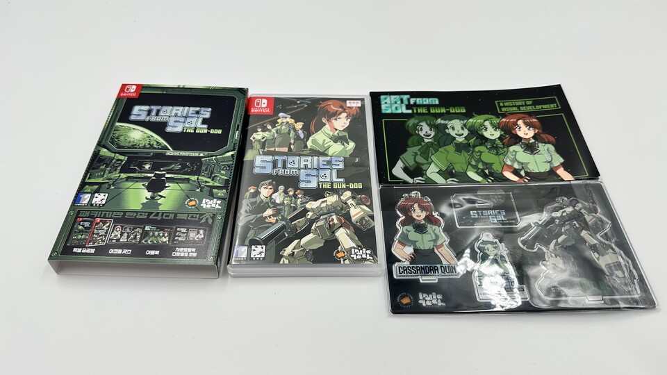 〈건도그: 태양계이야기〉 스위치 패키지 예약특전판 구성물, 왼쪽부터 슬리브, 타이틀, 아트북, 아크릴 굿즈. 여기에 사운드트랙 다운로드 코드가 동봉된다.