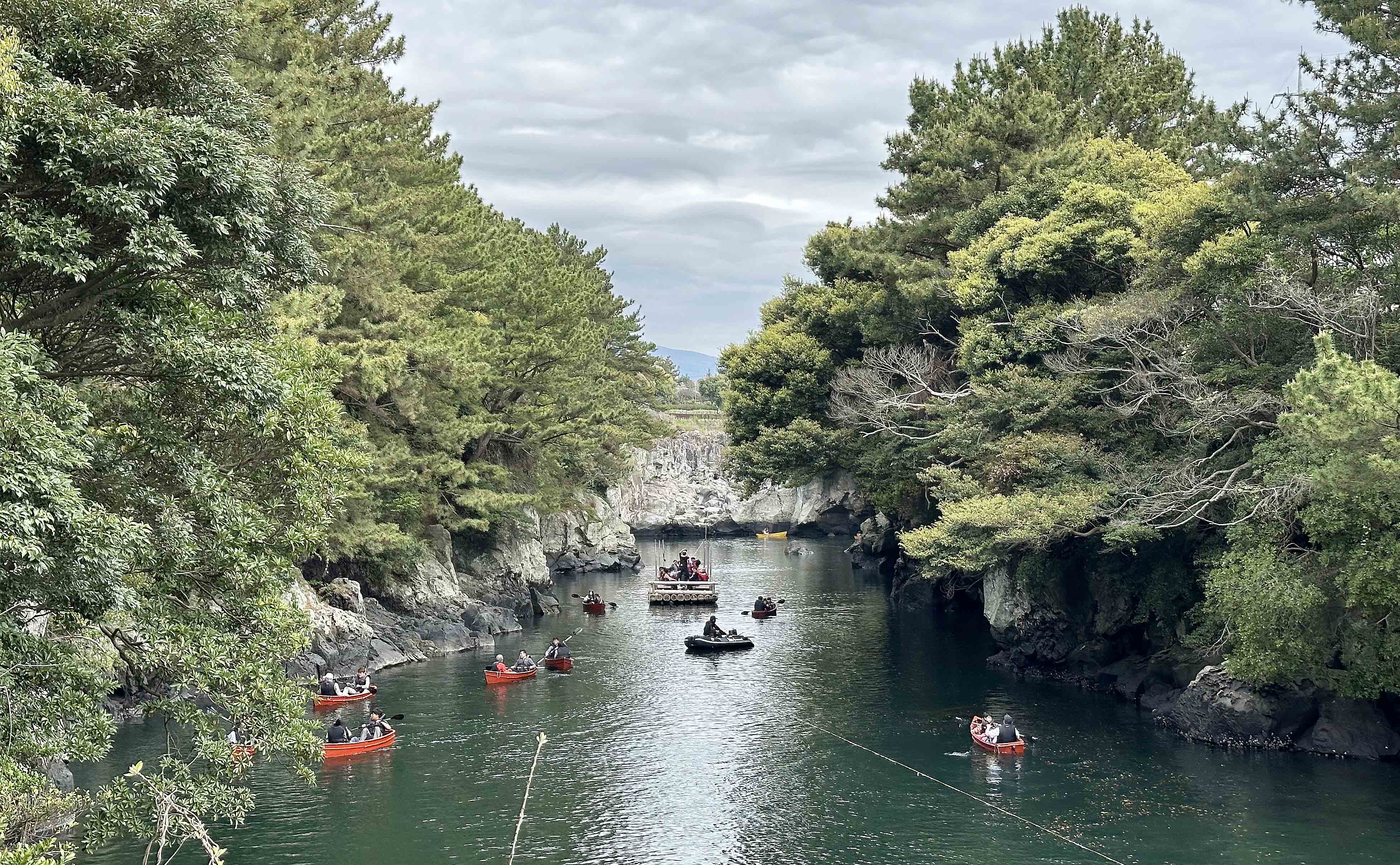 서귀포 칠십리의 비경 중 하나인 '쇠소깍'에서 관광객과 도민들이 카약과 제주 전통배 '테우'를 타고 있다.